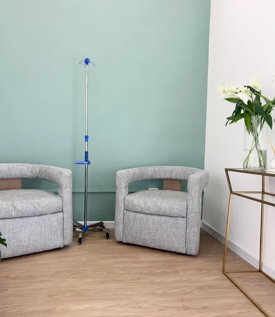IV therapy area with two armchairs and a drip stand beside a window